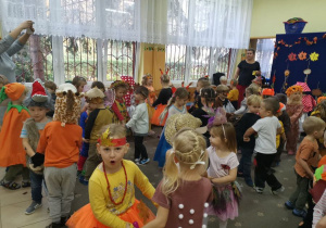 Dzieci w strojach jesiennych tańczą w parach.