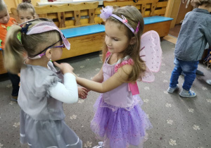 Dwie dziewczynki tańczą na balu jesieni.
