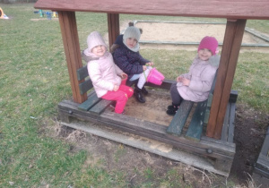 Dzieci z grupy drugiej siedzą w "pociągu"w ogrodzie przedszkolnym.