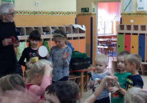 Trzech chłopców i dwie dziewczynki zaproszone na scenę przez prowadzącego graja na istrumentach perkusyjnych.