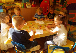 Dzieci lepią z plasteliny przy stoliku.