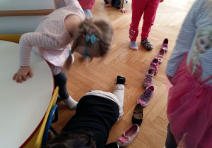 Dzieci ustawiają buty, jeden za drugim podczas jednej z wróżb andrzejkowych.