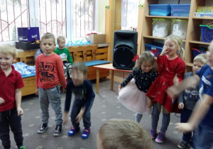 Dzieci stoją w kole podczas zabawy mikołajkowej