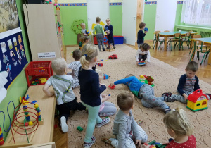Dzieci bawią się na dywanie zabawkami