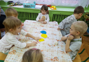 Dzieci przy stolikach lepią z ciastoliny