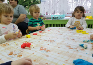 Dzieci przy stolikach lepią z ciastoliny