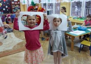 Dzieci prezentują wycinanki z papieru.