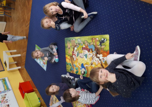 Dzieci układają puzzle na dywanie