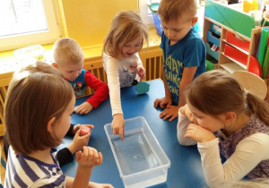 Dzieci sprawdzają, które przedmioty utrzymują się na powierzchni wody.