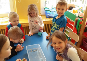 Dzieci sprawdzają, które przedmioty utrzymują się na powierzchni wody.