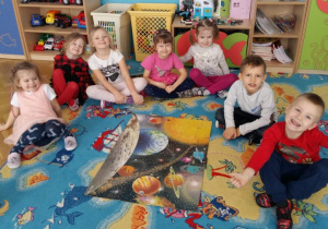 Dzieci układają puzzle przedstawiające Układ Słoneczny.