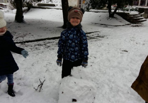 Zabawa dzieci na śniegu. Lepienie kul.