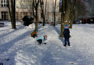 Zabawa dzieci na śniegu. Lepienie kul.