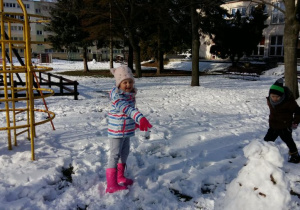 Zabawa dzieci na śniegu. Lepienie bałwana.