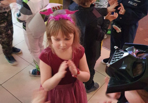 Dzieci przebrane w stroje karnawałowe tańczą na balu