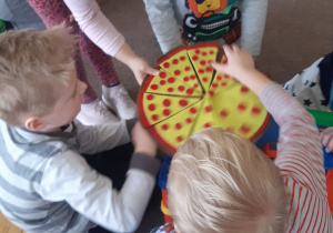 Dzieci układają elementy pizzy
