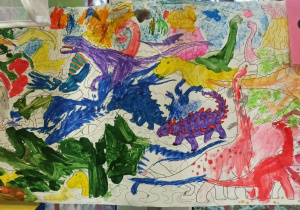 Praca plastyczna wykonana farbami plakatowymi, przedstawiająca dinozaury