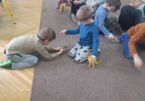 Zabawy dzieci figurkami dinozaurów