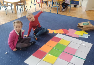 Dzieci układają symetrycznie elementy wzoru