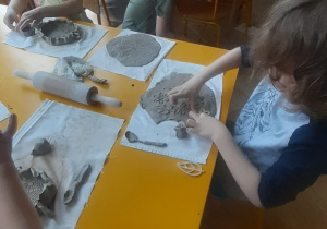 Dzieci siedzące przy stole, tworzą prace plastyczną