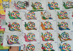 Praca plastyczna wykonana przez przedszkolaki w dniu kropki, przedstawiająca ślimaka