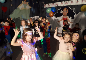 Dzieci z grupy III przebrane w stroje karnawałowe tańczą na balu karnawałowym