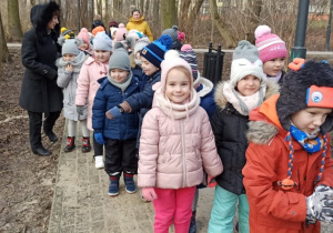 Dzieci z nauczycielkami na spacerze w parku, w pobliżu przedszkola