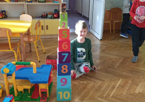 Chłopiec buduje wieżę z klocków