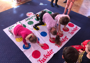 Dzieci grają w grę twister w sali przedszkolnej
