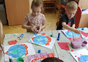 Dzieci wykonują pracę plastyczną, przedstawiającą planete Ziemię