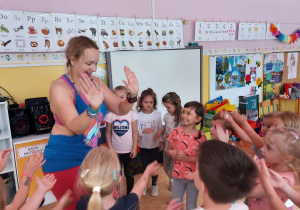 Dzieci 'przybijają piątkę" z instruktorką tańca