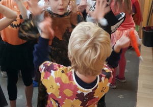 Dzieci przebrane w jesienne stroje, uczestniczą w zabawach na balu