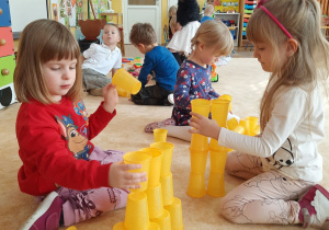 dzieci budują wieżę z plastikowych kubków