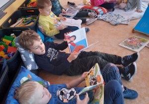 dzieci leżą po obiedzie i oglądają książki