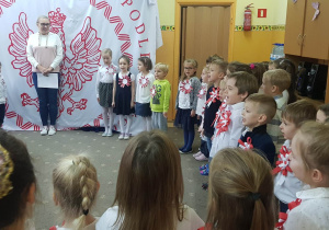 Dzieci ubrane na galowo śpiewają hymn Polski