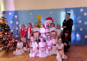 Dzieci z grupy 4 ubrane w świąteczne stroje wraz z nauczycielkami pozują do zdjęcia
