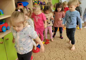 Dzieci przechodzą po ścieżce sensorycznej