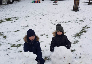 Dzieci lepią wielkie kule śniegu
