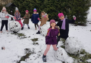 Dziewczynki pozują do zdjęcia przy kulach śniegu