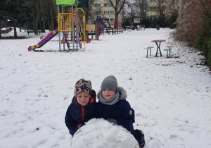 Dzieci lepią wielkie kule śniegu