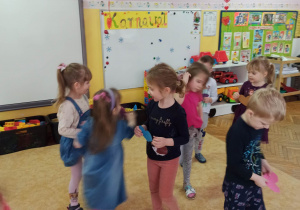 Dzieci poruszają się po sali z kolorowymi sercami