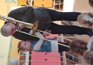 Dziewczynka "pomaga" muzykowi zagrać na puzonie