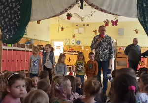 Dzieci wraz z muzykami stoją na scenie przedszkolnej