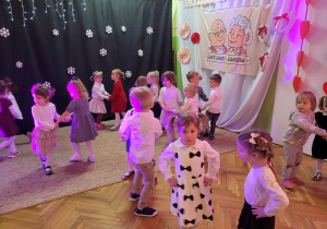 Dzieci ubrane odświętnie tańczą w parach w sali grupy pierwszej