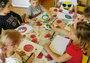 dzieci malują farbami przy stole