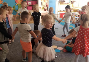 Dzieci tańczą w kole, wybierają odpowiednie kolory kropek