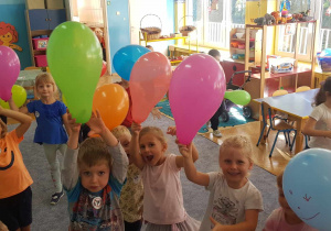 Dzieci z balonami w sali przedszkolnej