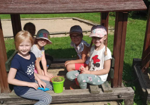 Dzieci siedzące w "pociągu" w ogrodzie przedszkolnym