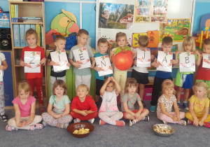 Dzieci pozują do zdjęcia z napisem dzień jabłka