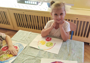Dzieci rysują koszyk z jabłkami na kartce papieru